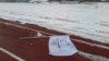 A flag bearing the logo of 2018 Winter Olympic Games lies on the ground at the proposed site of the Olympic Stadium near the Alpensia Resort in the mountain cluster of PyeongChang, February 10, 2015.
