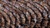 FILE - Men and women pump their fists in the air and chant "Defend!" as they carry propaganda slogans calling for reunification of their country during the "Pyongyang Mass Rally on the Day of the Struggle Against the U.S."