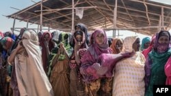 FILE - Women gather for a food distribution at the Farbudo internally displaced person camp, in Gode, near Kebri Dahar, southeastern Ethiopia, Jan. 27, 2018.