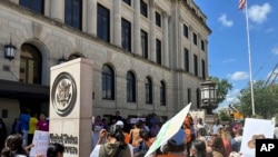 Opositores a una ley de inmigración de Iowa se manifiestan afuera de una corte federal en Des Moines, Iowa, el lunes 10 de junio de 2024. 