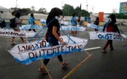 Protesters march under the rain towards the Philippine Congress to protest the 4th State of the Nation (SONA) address by President Rodrigo Duterte Monday, July 22, 2019 in suburban Quezon city, northeast of Manila, Philippines.