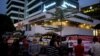 A "Pray for Jakarta" message (top) is displayed on a screen as Indonesians gather outside the damaged Starbucks coffee shop in central Jakarta on Jan. 17, 2016 following the deadly gun and bomb attacks that rocked the city on Jan. 14. 