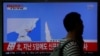 A passenger walks past a TV broadcasting a news report on North Korea's failed missile launch from its east coast, at a railway station in Seoul, South Korea, April 16, 2017. 