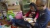 FILE - A father reads a book with his autistic daughter.
