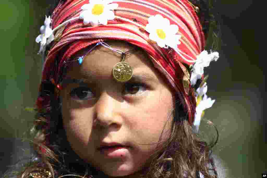 Seorang gadis Roma berpose untuk para fotografer dalam Festival 'Hidirellez' di Edirne, Turki, dekat Perbatasan Yunani dan Bulgaria. Festival The 'Hidirellez' menarik ribuan orang untuk merayakan dimulainya musim semi dengan menari, menghidupkan api unggun dan mandi di Sungai Tundzha.