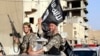 Fighters with the militant group Islamic State in Iraq and the Levant (ISIL, also called ISIS by some) wave flags as they take part in a military parade along the streets of Raqqa province, northern Syria, June 30, 2014. 