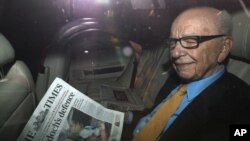 News Corp Chief Executive and Chairman Rupert Murdoch holds a copy of T"he Times" newspaper as he leaves his home in London, England, July 20, 2011. (Reuters)