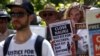 FILE - Protesters react as they hold placards and listen to speakers during a rally in support of refugees in central Sydney, Australia, Oct. 19, 2015. 