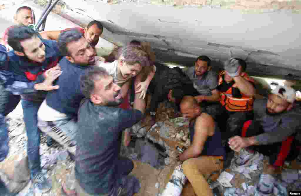 Los equipos de rescate llevan a una ni&#241;a mientras buscan v&#237;ctimas entre los escombros en el lugar de los ataques a&#233;reos israel&#237;es, en la ciudad de Gaza.