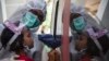 Seorang petugas medis melakukan test swab COVID-terhadap seorang anak di Surabaya (foto: AFP). RRI menutup siaran di Zona Merah termasuk RRI Surabaya. 