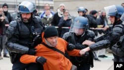 Riot police officers detain a striking train worker outside the the Gare de Lyon train station, Dec. 23, 2019 in Paris. 