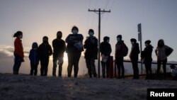 Migrantes en busca de asilo de América Central esperan transporte después de cruzar el río Grande hacia los Estados Unidos desde México en una balsa en Peñitas, Texas, el 12 de marzo de 2021.