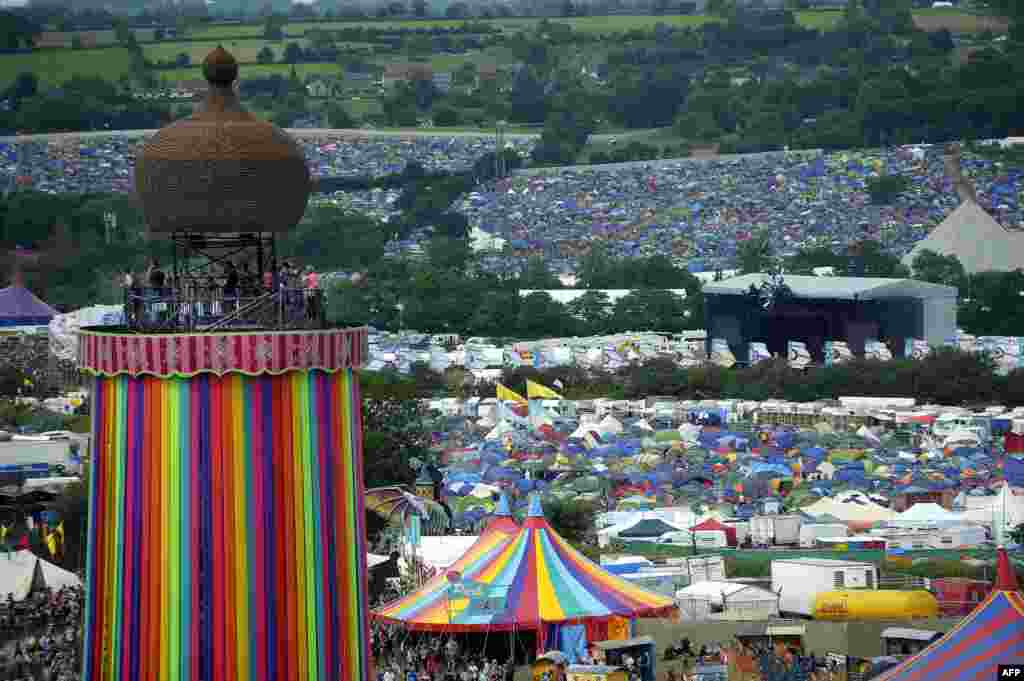 Para penonton dengan bertenda, menikmati festival musik Glastonbury di Somerset, Inggris.