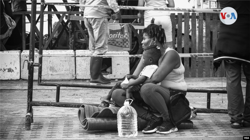 Ni&#241;os y adolescentes esperan con sus padres en las puertas del puerto de Necocl&#237; para abordar una de las embarcaciones que los lleve a continuar su camino en busca del sue&#241;o americano.