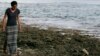 FILE - Poet and global warming activist Kathy Jetnil-Kijiner walks along the shore at low tide in Majuro Atoll in the Marshall Islands, Nov. 8, 2015.