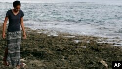 FILE - Poet and global warming activist Kathy Jetnil-Kijiner walks along the shore at low tide in Majuro Atoll in the Marshall Islands, Nov. 8, 2015.