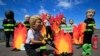 A man wearing a Trump mask, center, is joined by other 'world leaders' during a protest ahead of the G-7 summit in Biarritz, France, Aug. 23, 2019. 