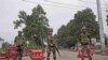 Indian paramilitary soldiers stand guard near a temporary check post on the road leading towards Independence Day parade venue during lockdown in Srinagar, Indian controlled Kashmir, Aug. 15, 2019.