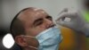 Un trabajador de la salud toma una muestra de un hombre para ser examinado por la enfermedad del coronavirus (COVID-19), en Buenos Aires, el 7 de abril de 2021.