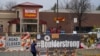 FILE - Tributes cover the temporary fence around the King Soopers grocery store in which 10 people died in a mass shooting in late March in Boulder, Colorado, April 23, 2021.
