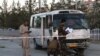 Afghan security personnel investigate a damage bus carrying employees of Khurshid TV, at the site of a bomb blast in Kabul, August 4, 2019.