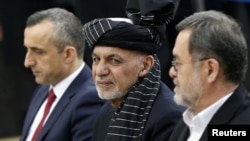 FILE - Afghanistan's President Ashraf Ghani, alongside his two vice president candidates, Amrullah Saleh, left, and Sarwar Danish, arrives to register as a candidate for the presidential election at Afghanistan's Independent Election Commission in Kabul, 