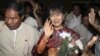 Myanmar opposition leader Aung San Suu Kyi, center, arrives at Rangoon International airport before departing for India in Rangoon, Burma Nov. 12, 2012.