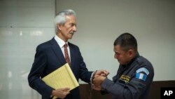 Un guardia le quita las esposas al galardonado periodista José Rubén Zamora cuando llega al primer día de su juicio por cargos de lavado de dinero, en Ciudad de Guatemala, el martes 2 de mayo de 2023.