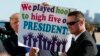 President Donald Trump holds a sign given to him by a crowd of supporters after landing at Dallas Love Field airport, Oct. 25, 2017, in Dallas.