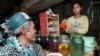 រូបឯកសារ៖ អតិថិជន​ម្នាក់​រង់ចាំ​អ្នក​លក់​ដួស​ស្រា​ស​ឲ្យ នៅ​តៀម​លក់​ស្រា​មួយ​ក្នុង​រាជធានី​ភ្នំពេញ។ 