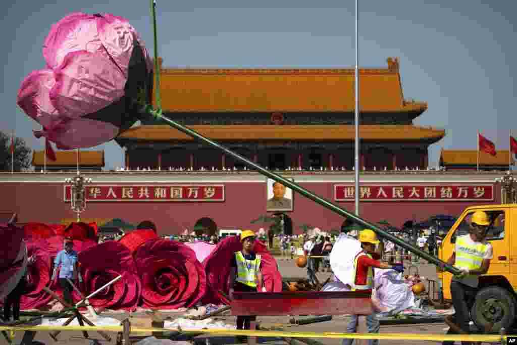 Para pekerja berusaha memasang instalasi &#39;bunga mawar&#39; di Lapangan Tiananmen, Beijing.