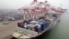 A cargo ship loaded with containers is seen anchored at a port in Qingdao, Shandong province, China, July 10, 2013.