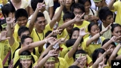 Students flash the 'L' sign for Laban or Fight as they join the march celebrating the 25th anniversary of People Power revolution, February 25, 2011 in suburban Pasig City east of Manila, Philippines