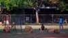 FILE - Members of the Australian Aboriginal community of Ramingining can be seen near their homes in East Arnhem Land, located east of the Northern Territory city of Darwin. Doctors urge that alcohol be banned in the troubled town of Tennant Creek for five years.