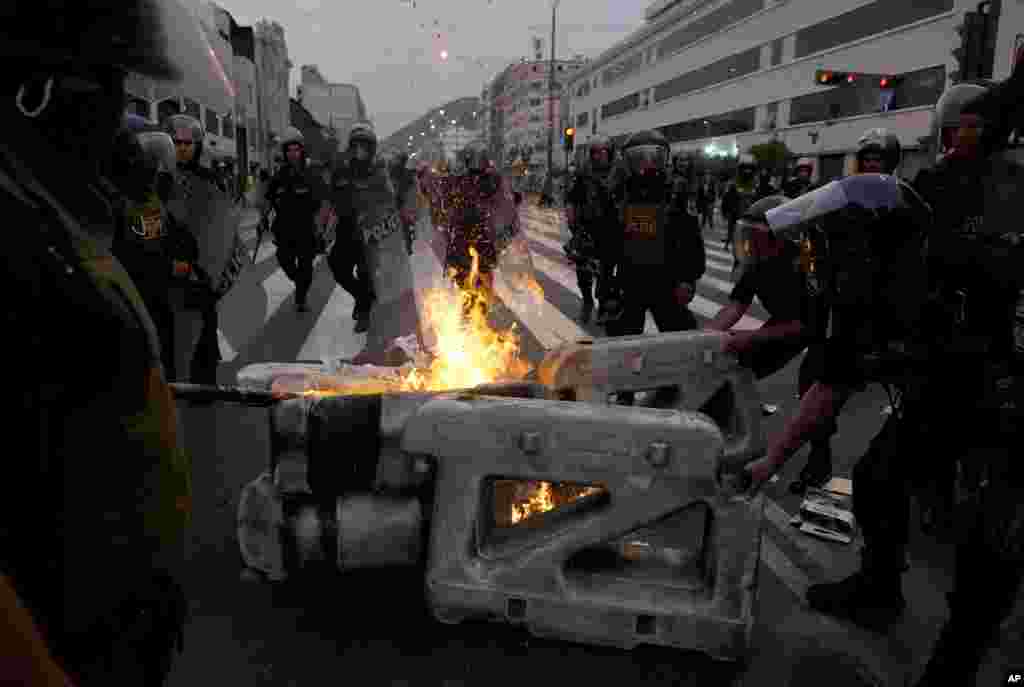 La policía desmantela una barricada en llamas instalada por partidarios del derrocado presidente Pedro Castillo durante enfrentamientos con la policía en Lima, Perú, el jueves 8 de diciembre de 2022. (Foto AP/Fernando Vergara)