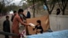 Afganos distribuyen donaciones de alimentos en un campamento de desplazados internos en Kabul, Afganistán, el 13 de septiembre de 2021. 