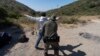 Un agente de la Patrulla Fronteriza de EEUU registra a un inmigrante que desea obtener asilo antes de que el hombre sea trasladado y procesado, el 5 de junio de 2024, cerca de Dulzura, California. 