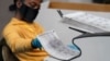FILE - A county election worker scans mail-in ballots at a tabulating area at the Clark County Election Department, Nov. 5, 2020, in Las Vegas. 