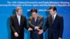 South Korea's Trade, Industry and Energy Minister Yoon Sang-jick, center, tries to hold hands to pose for the media with Japan's Economy, Trade and Industry Minister Motoo Hayashi, left, and China International Trade Representative Zhong Shan before the 1