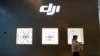 Seorang perempuan melewati toko produsen drone China, DJI, di dalam sebuah pusat perbelanjan di Beijing, 15 Desember 2021. (Foto: Carlos Garcia Rawlins/Reuters)