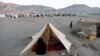 FILE - Internally displaced Afghan family sits inside a tent at a refugee camp in Herat province, Afghanistan, Oct. 14, 2018. 