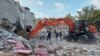 Warga mencari korban selamat di antara reruntuhan gedung di kota pantai Izmir, pasca gempa kuat melanda kawasan Laut Aegea, Turki tenggara hari Jumat (30/10). 