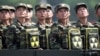FILE- North Korean soldiers turn and look towards their leader Kim Jong Un from a military parade vehicle as they carry packs marked with the nuclear symbol during a ceremony marking the 60th anniversary of the Korean War armistice in Pyongyang, North Kor