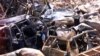Polisi forensik berjalan melewati mobil-mobil yang hancur di dekat lokasi ledakan bom 12 Oktober 2002 di Kuta, Bali, 18 Oktober 2002. Tiga tersangka yang diduga terlibat pemboman di Indonesia antara tahun 2002-2003 akan diadili pengadilan militer AS. (Foto: Reuters)