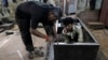 An Indian worker hammers on a steel cupboard at a metal wardrobe factory in Mumbai, India, Oct. 12, 2012.