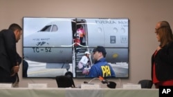 La ministra argentina de Seguridad, Patricia Bullrich, (Der), mira un video que, según ella, muestra la expulsión de Argentina de la familia del narcotraficante ecuatoriano fugitivo José Adolfo "Fito" Macías, en una conferencia de prensa en Buenos Aires, el 19 de enero de 2024.