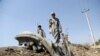Afghan boys collects the remains of a suicide attacker's vehicle in Kabul, Afghanistan, Wednesday, July 24, 2019. 