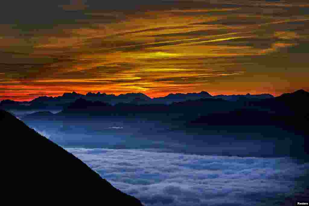 Kabut menyelimuti bukit Inntal saat matahari terbit terlihat dari pegunungan Hundskopf di desa Gnadenwald, Austria barat.