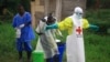 FILE - In this photo taken Sept. 9, 2018, a health worker sprays disinfectant on his colleague after working at an Ebola treatment center in Beni, DRC.