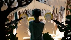 A Filipino boy watches a display depicting alleged harassment of the military to people in the provinces, as demonstrators call for an end to martial law during a rally near the Malacanang palace in Manila, Philippines on Dec. 7, 2018. 